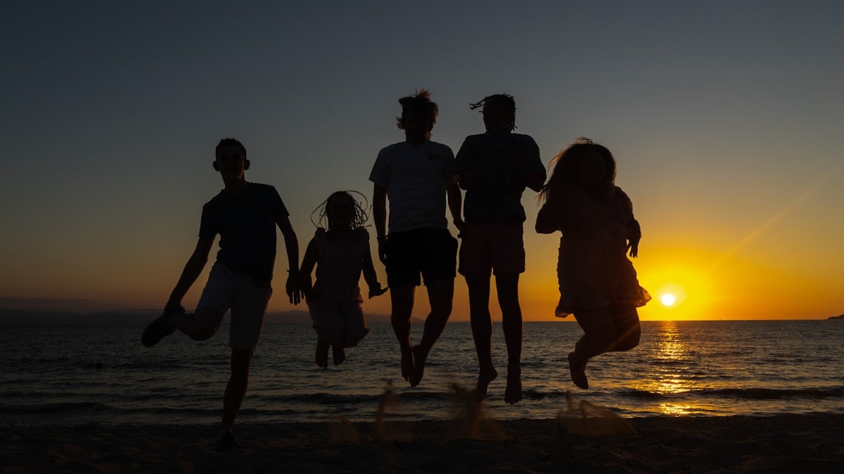 Family photo against a sunset on a beach in Mexico